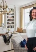 Photo of Sonia standing in a beautiful, light color living room.